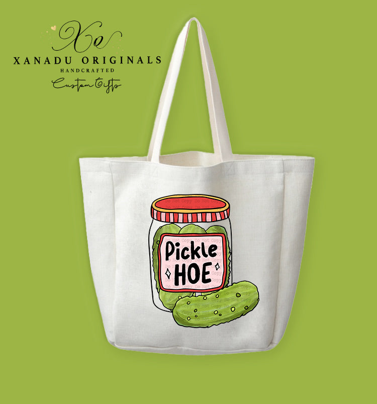 A cream-colored polyester linen tote bag featuring a vibrant doodle-style illustration of a pickle jar and a whole dill pickle with a label that reads "Pickle HOE".