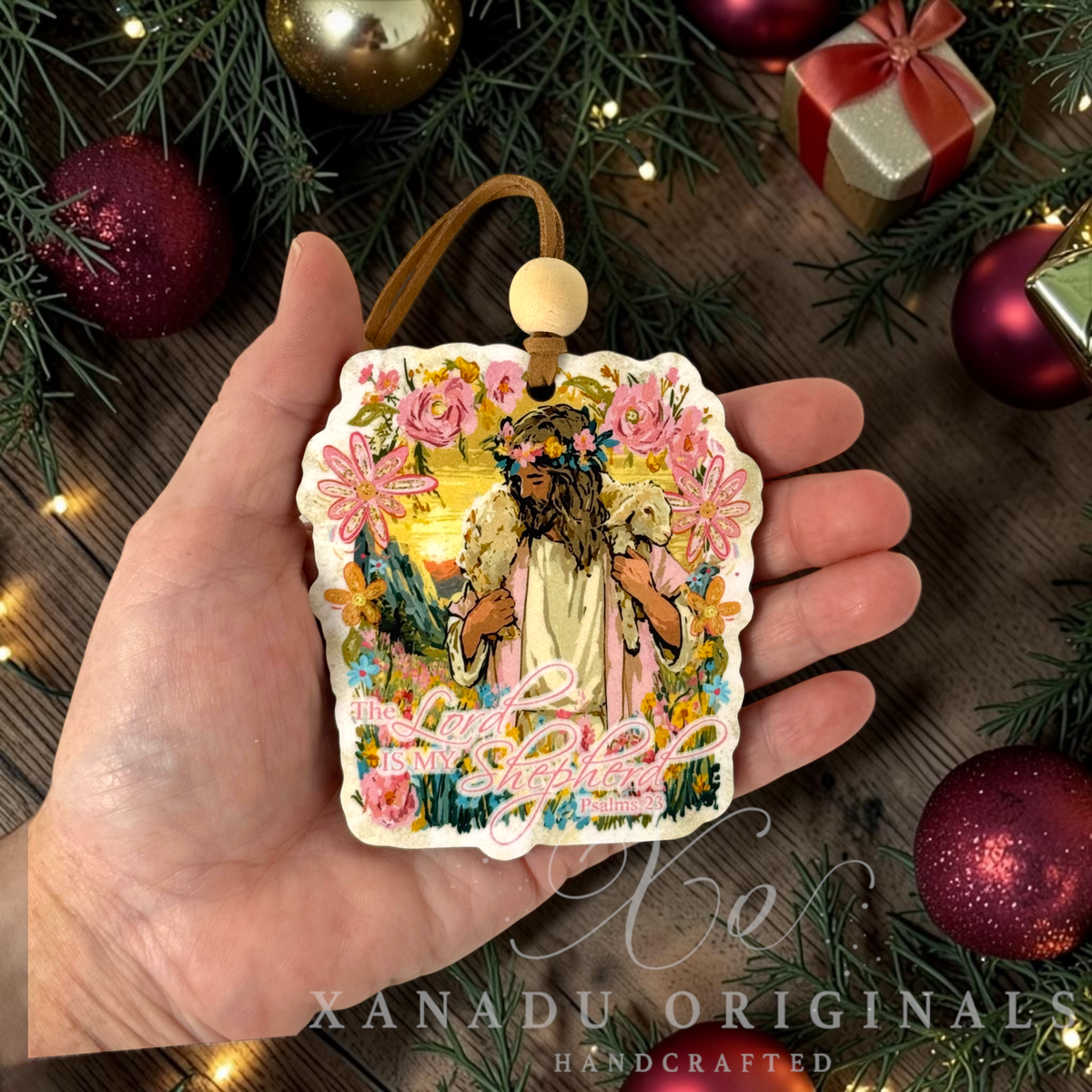 Retro religious Christian Good Shepherd ornament measuring 3.2 by 3.55 inches held in a hand next to holiday tree decorations.