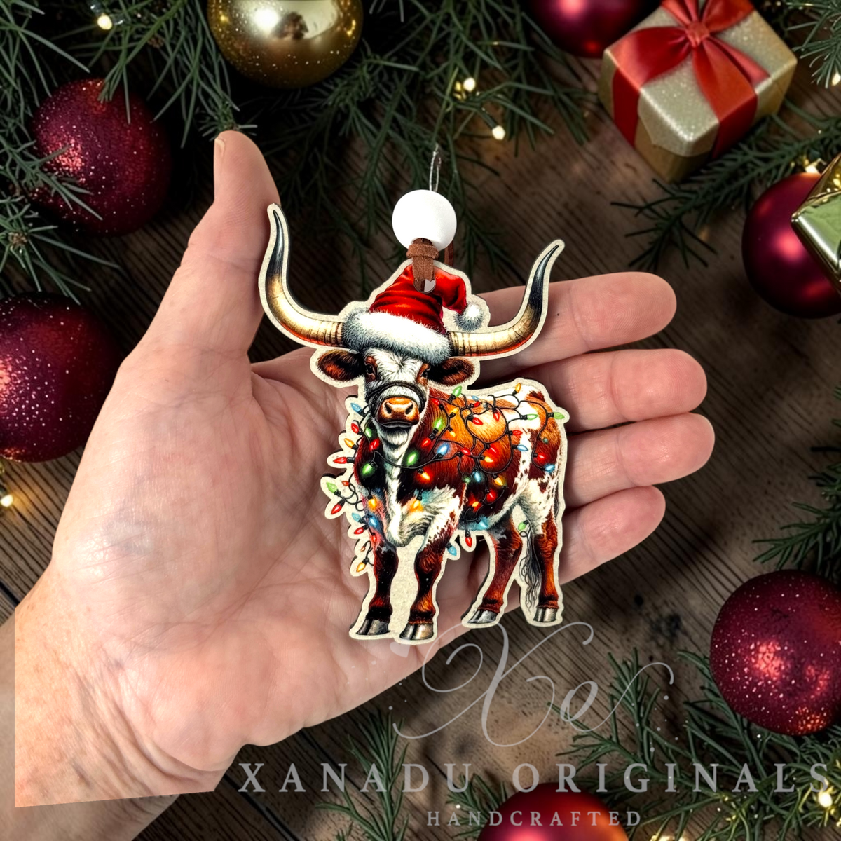 Whimsical western animal holiday Christmas ornament measuring 2.86 by 3.9 inches held in a hand next to holiday decorations.