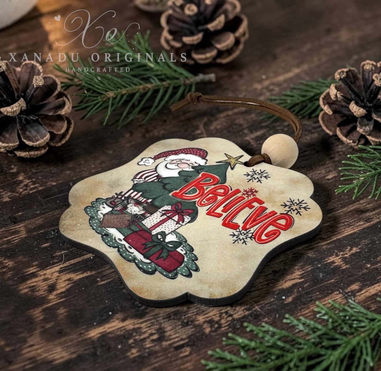 Close-up angled view of a scalloped wood Christmas ornament displaying the clean dark laser-cut edges, matte texture finish, and brown faux suede hanging cord.