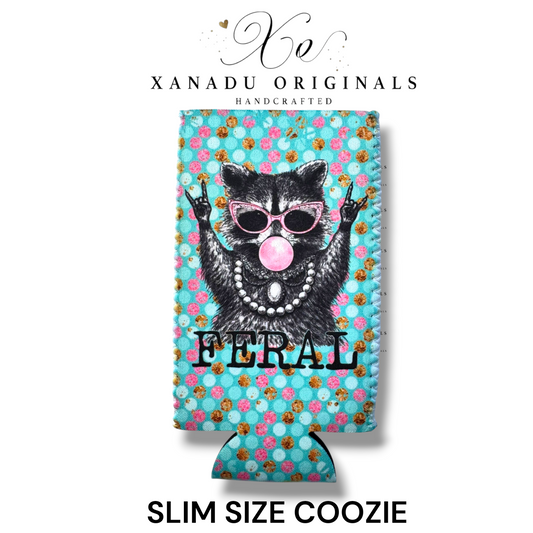 "Xanadu Originals handcrafted slim size neoprene can coozie featuring an illustrated raccoon with pink sunglasses, a pearl necklace, and bubblegum throwing rock-on signs with the text 'FERAL' over a teal and pink polka-dot background."
