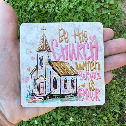 3.6 inch square MDF wood coaster with rounded corners featuring a sketch-style illustration of a white country church chapel with a gold steeple, surrounded by pink and gold hearts, with stylized hand-lettered text reading Be the Church when Service is Over.