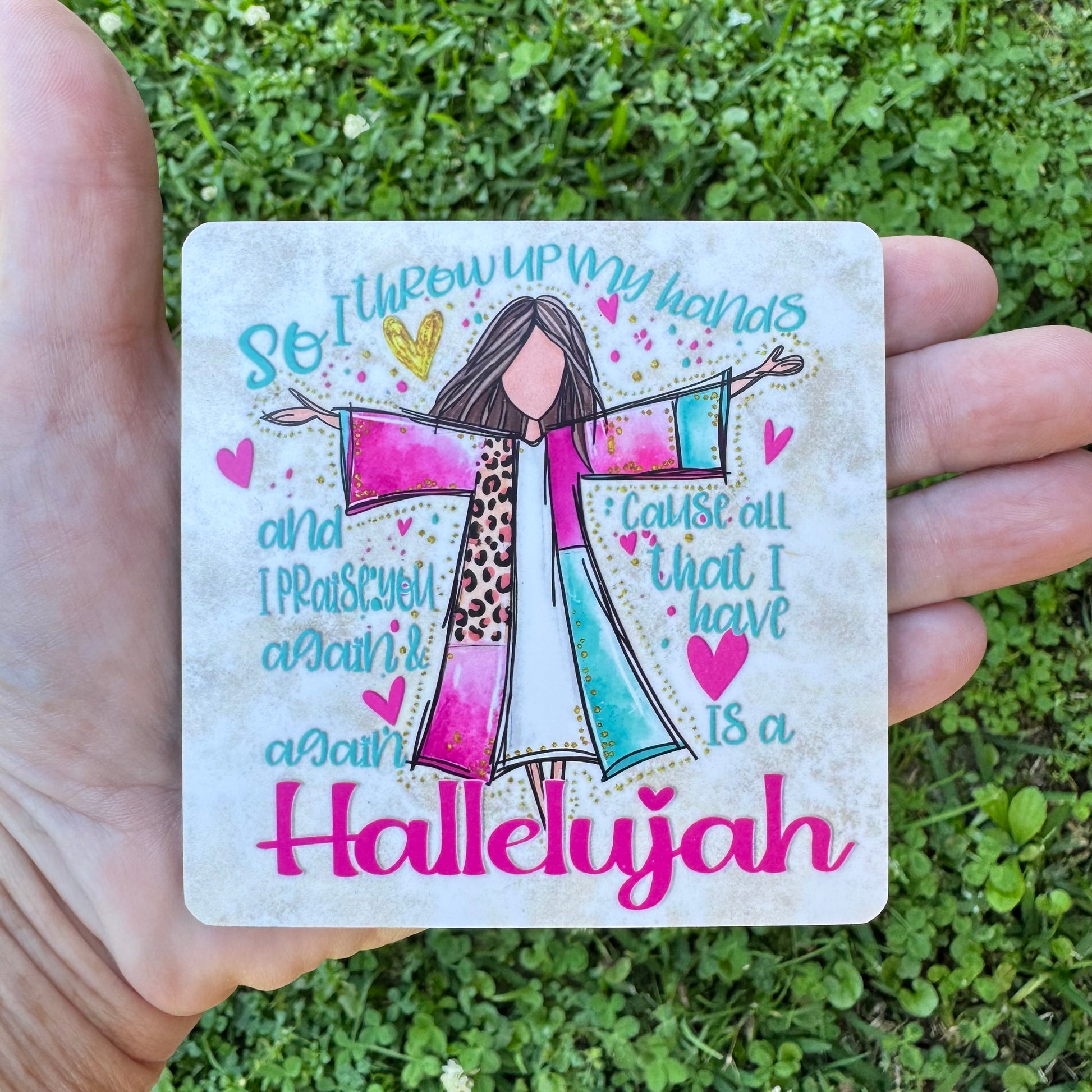 3.6 inch square MDF wood coaster with rounded corners featuring an illustration of a faceless woman worshiping with outspread hands in a pink, blue, and leopard print robe, surrounded by hearts, gold speckles, and stylized typography reading So I throw up my hands and I Praise You again & again Cause all that I have is a Hallelujah.