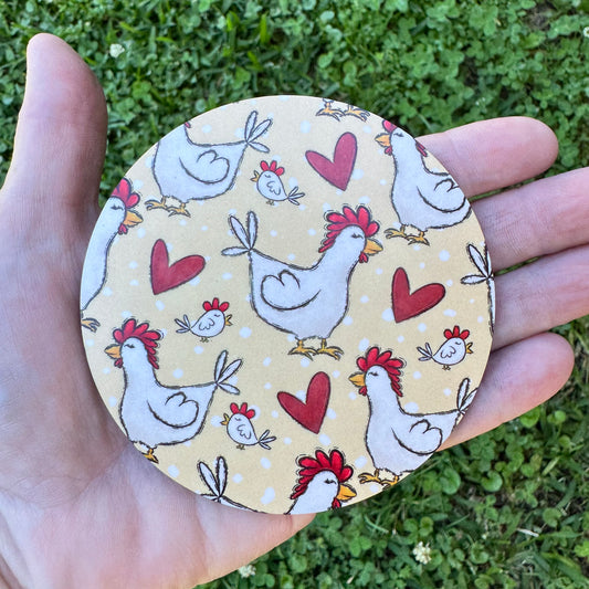 3.6 inch round circular MDF wood coaster featuring a repeating pattern of sketched white hens with red crests, small baby chicks, and red hearts on a light yellow polka dot background.