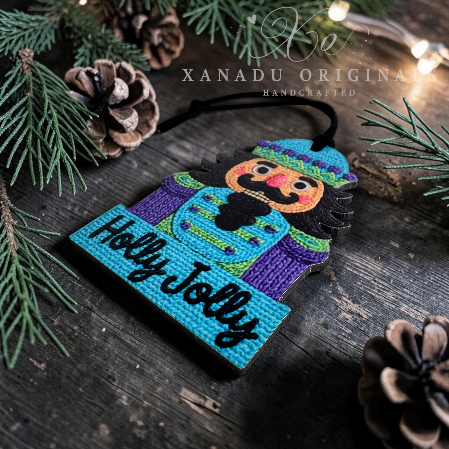 A handcrafted nutcracker ornament on a dark rustic wooden surface, surrounded by pine branches, pinecones, and warm string lights. The ornament features a colorful painted nutcracker figure and the words 'Holly Jolly' in black script on a turquoise base.