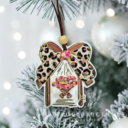 Decorative Christmas ornament by Xanadu Originals, featuring a leopard print bow, a pink and gold star on a flocked christmas tree branch.