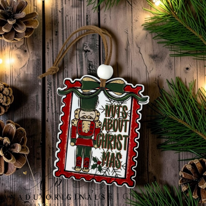 Nuts About Christmas wood ornament featuring a retro nutcracker illustration in a red postage stamp frame with green bow and holiday typography.