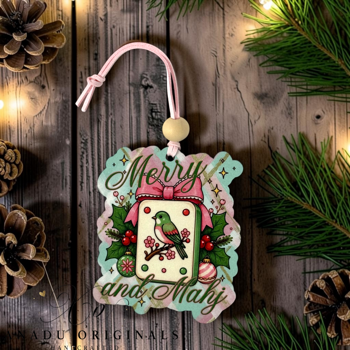 Merry and Mahj wood ornament featuring a retro Mahjong tile illustration with a green bird, pink ribbon bow, and holly leaves on a mint background.