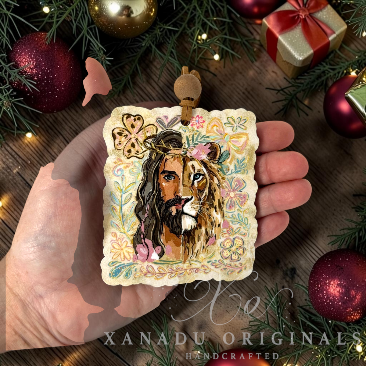 Retro Christian lion and Jesus ornament measuring 3.18 by 3.65 inches being held in a hand next to holiday tree branches and ornaments.