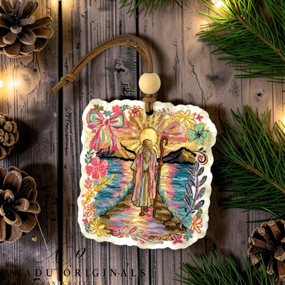 Moses Parting the Red Sea wood ornament featuring a colorful folk art illustration of Moses looking at a bright sunburst between parted waters with floral accents.