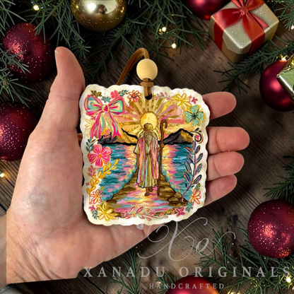 Retro religious Bible story Christmas ornament measuring 3.26 by 3.55 inches held in a hand next to festive holiday decorations.

