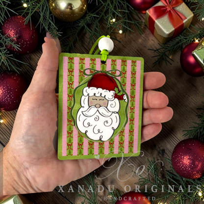 Whimsical retro Santa Claus Christmas ornament measuring 3.03 by 3.75 inches held in a hand next to festive holiday decorations.
