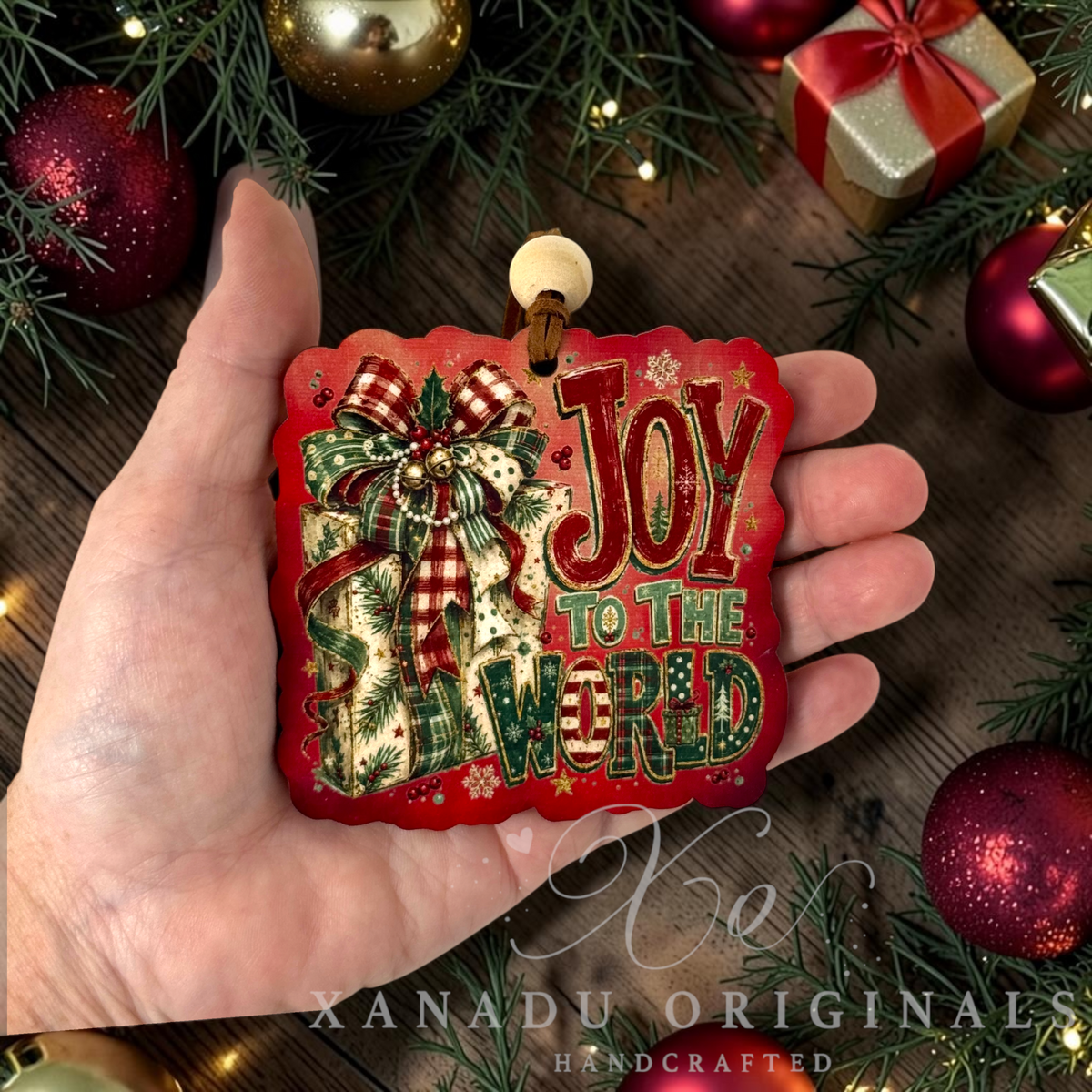 • Retro religious Christmas present ornament measuring 3.45 by 3.33 inches held in a hand next to holiday tree decorations.
