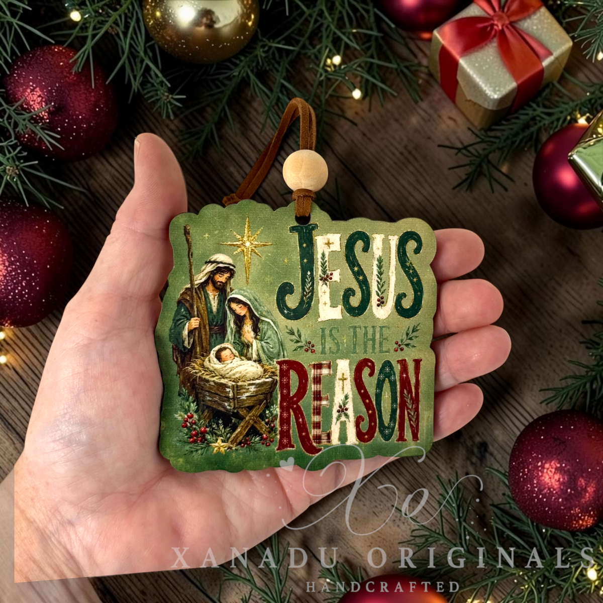 Retro religious Christmas nativity ornament that says Jesus Is The Reason  measuring 3.45 by 3.39 inches held in a hand next to holiday tree decorations.