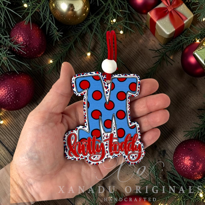 Whimsical Southern college football gameday holiday Christmas ornament measuring 3.15 by 3.65 inches held in a hand next to festive decorations.
