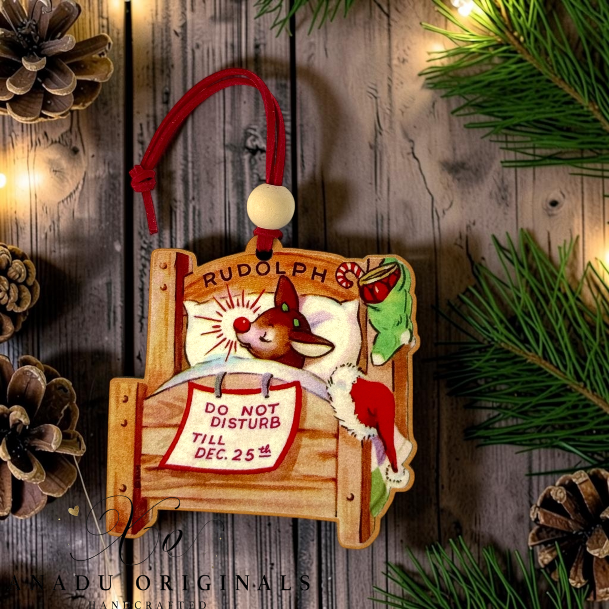 Rudolph the Red Nosed Reindeer wood ornament featuring a retro illustration of Rudolph sleeping in a wooden bed with a Do Not Disturb Till Dec 25th sign.