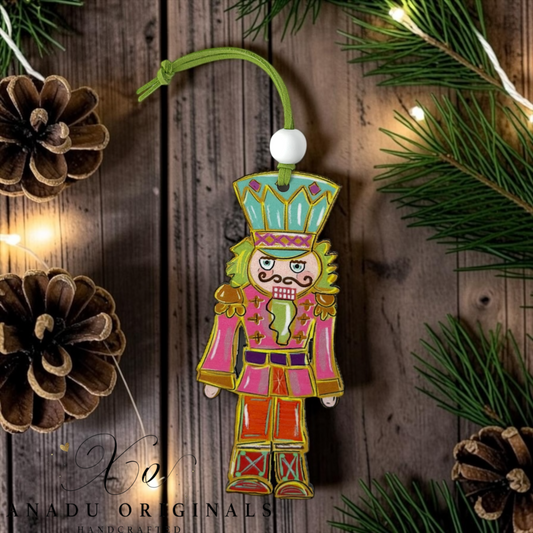 Retro blushing nutcracker acrylic ornament featuring a full length toy soldier illustration in pink and orange with a teal crown on a die cut wood shape.