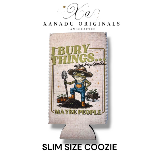 "Xanadu Originals handcrafted slim size neoprene can coozie featuring an illustrated green frog gardener in overalls holding a shovel with the text 'I bury things... may be plants... MAYBE PEOPLE' on a rustic canvas-textured background."