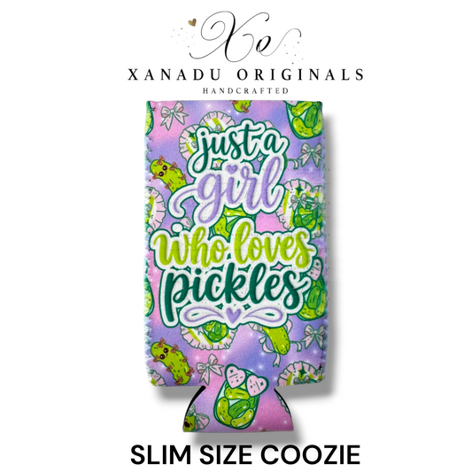"Xanadu Originals handcrafted slim size neoprene can coozie featuring a vibrant green and purple pattern with cartoon pickle characters, bows, and the stylized text 'Just a girl who loves pickles'."