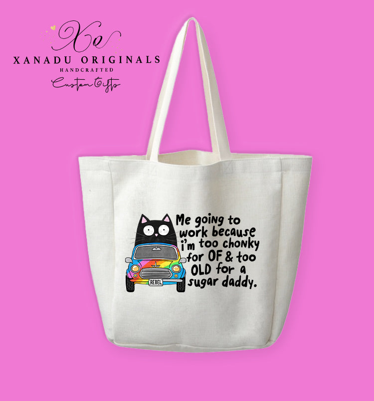 A cream-colored polyester linen tote bag featuring a cartoon illustration of a wide-eyed black cat driving a small vintage car with rainbow panels and a license plate reading "REBEL." Black text to the right reads "Me going to work because i'm too chonky for OF & too OLD for a sugar daddy."