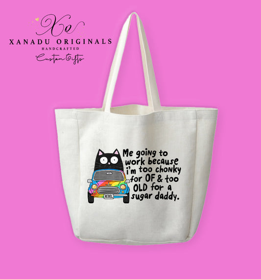 A cream-colored polyester linen tote bag featuring a cartoon illustration of a wide-eyed black cat driving a small vintage car with rainbow panels and a license plate reading "REBEL." Black text to the right reads "Me going to work because i'm too chonky for OF & too OLD for a sugar daddy."