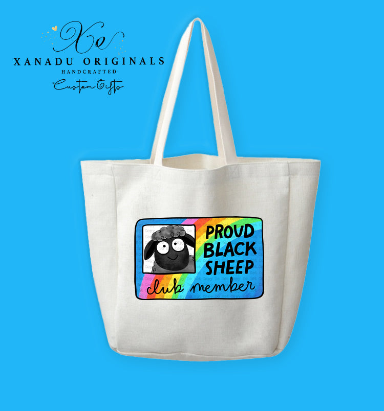 A cream-colored polyester linen tote bag featuring a rounded square graphic with a bright retro rainbow pattern. On the left side is a framed portrait of a smiling, wide-eyed black sheep next to text that reads "PROUD BLACK SHEEP club member" in black block letters and pink script.