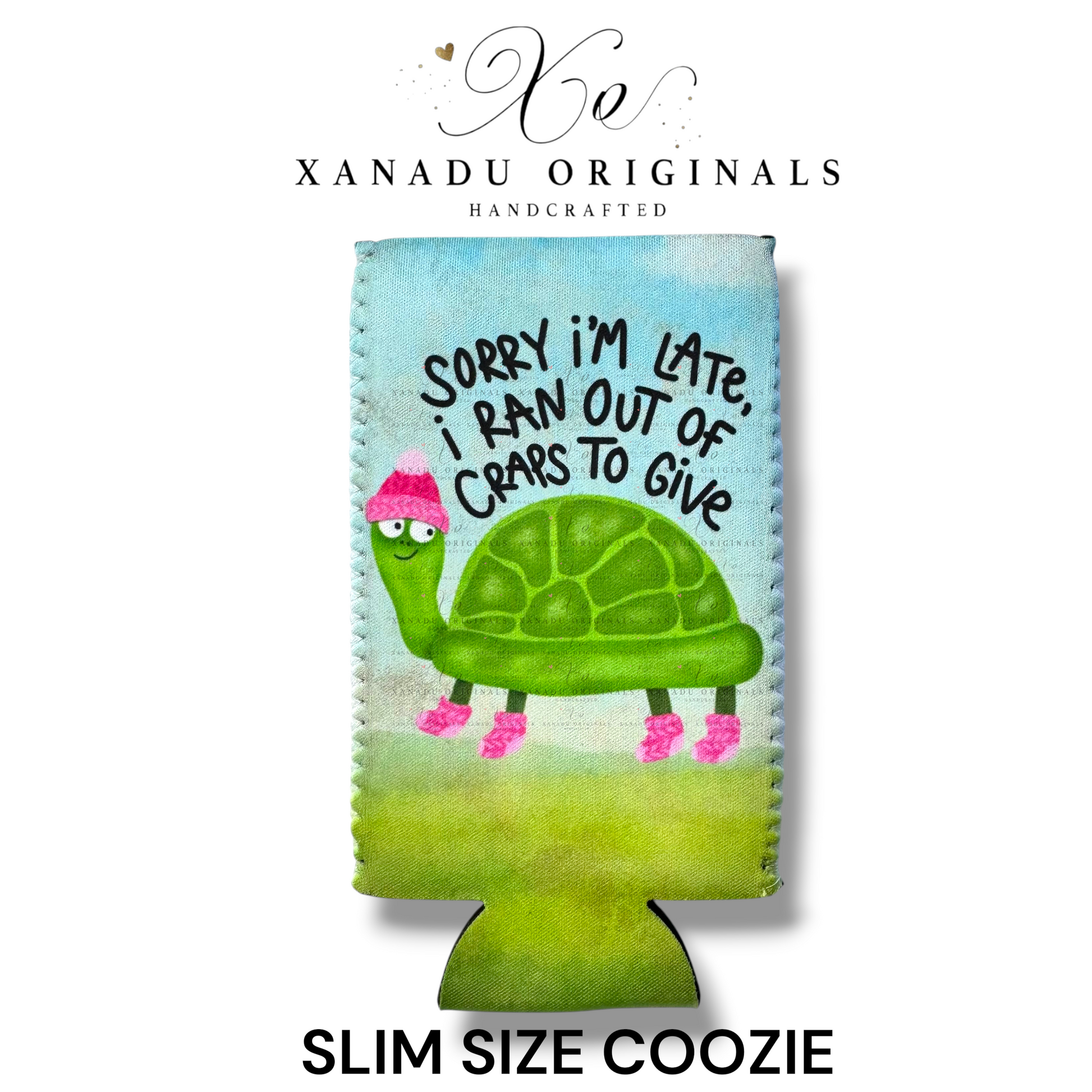"Xanadu Originals handcrafted slim size neoprene can coozie featuring a slow-moving green turtle wearing a pink winter hat and socks with the sarcastic text 'Sorry I'm late, I ran out of craps to give' on a soft green and blue background."