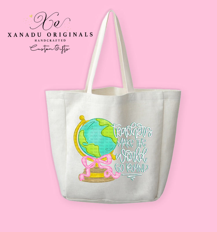 A cream-colored polyester linen tote bag featuring a watercolor illustration of a green and blue desk globe with a golden base wrapped in a bright pink ribbon bow, sitting next to white and grey stylized script text reading "Teachers MAKE THE world GO ROUND."