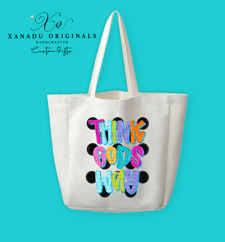 A cream-colored polyester linen tote bag featuring a graphic print of a grid of nine large black polka dots. Layered on top is stylized, multi-colored 3D bubble lettering in pink, orange, purple, and blue that reads "THINK GOD'S WAY."
