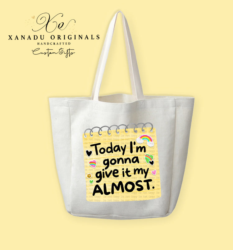 A cream-colored polyester linen tote bag featuring a graphic illustration of a yellow spiral-bound notebook page filled with small colorful heart, rainbow, and smiley face doodles around bold black text that reads "Today I'm gonna give it my ALMOST."