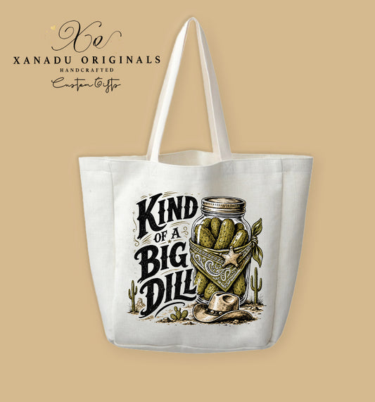 A cream-colored polyester linen tote bag featuring a detailed country western illustration of a mason jar full of pickles wearing a bandana and cowboy hat next to the text "KIND OF A BIG DILL".